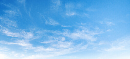Clear blue sky with wispy white clouds
