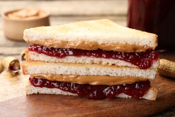 Tasty sandwiches with peanut butter, jam and nuts on table, closeup