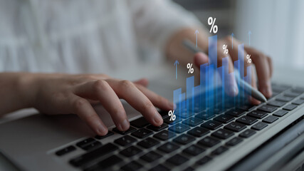 Close-up of hands working on a laptop keyboard with digital graphs and percentages, illustrating concepts of financial growth and data analysis in a bright workspace. Cyphers