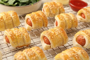 Puff pastry. Tasty sausages in dough and ketchup on white wooden table, closeup