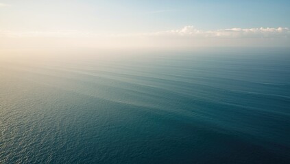Wide ocean horizon with light cloud cover