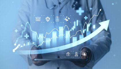 Medical professional holding tablet with rising financial chart and healthcare icons illustrating growth, innovation and progress in modern medical business.