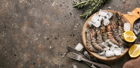 Fresh raw shrimp on ice with lemon and rosemary