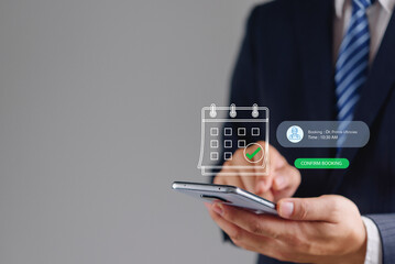 Businessman using smartphone with digital medical appointment booking calendar hologram in online healthcare concept. Professional confirming doctor schedule via modern application.
