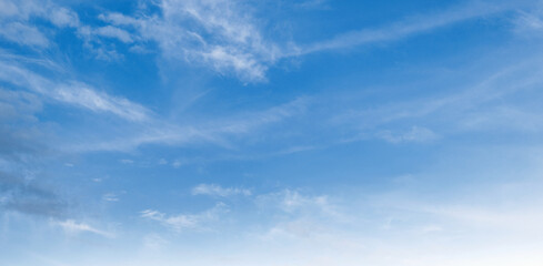 Clear blue sky with wispy clouds drifting gently