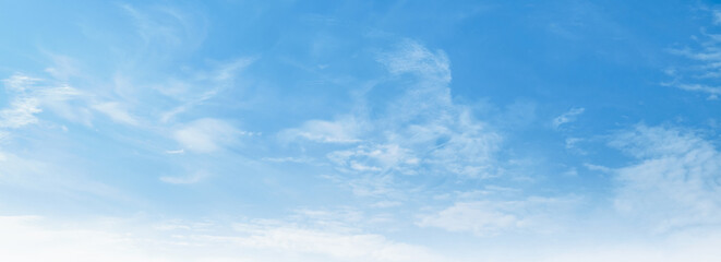 Clear blue sky with wispy clouds drifts gently