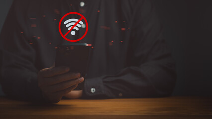 Man holding a smartphone with a red no wifi icon. This offline digital technology concept shows internet network connection error, communication problem, and disconnected signal.
